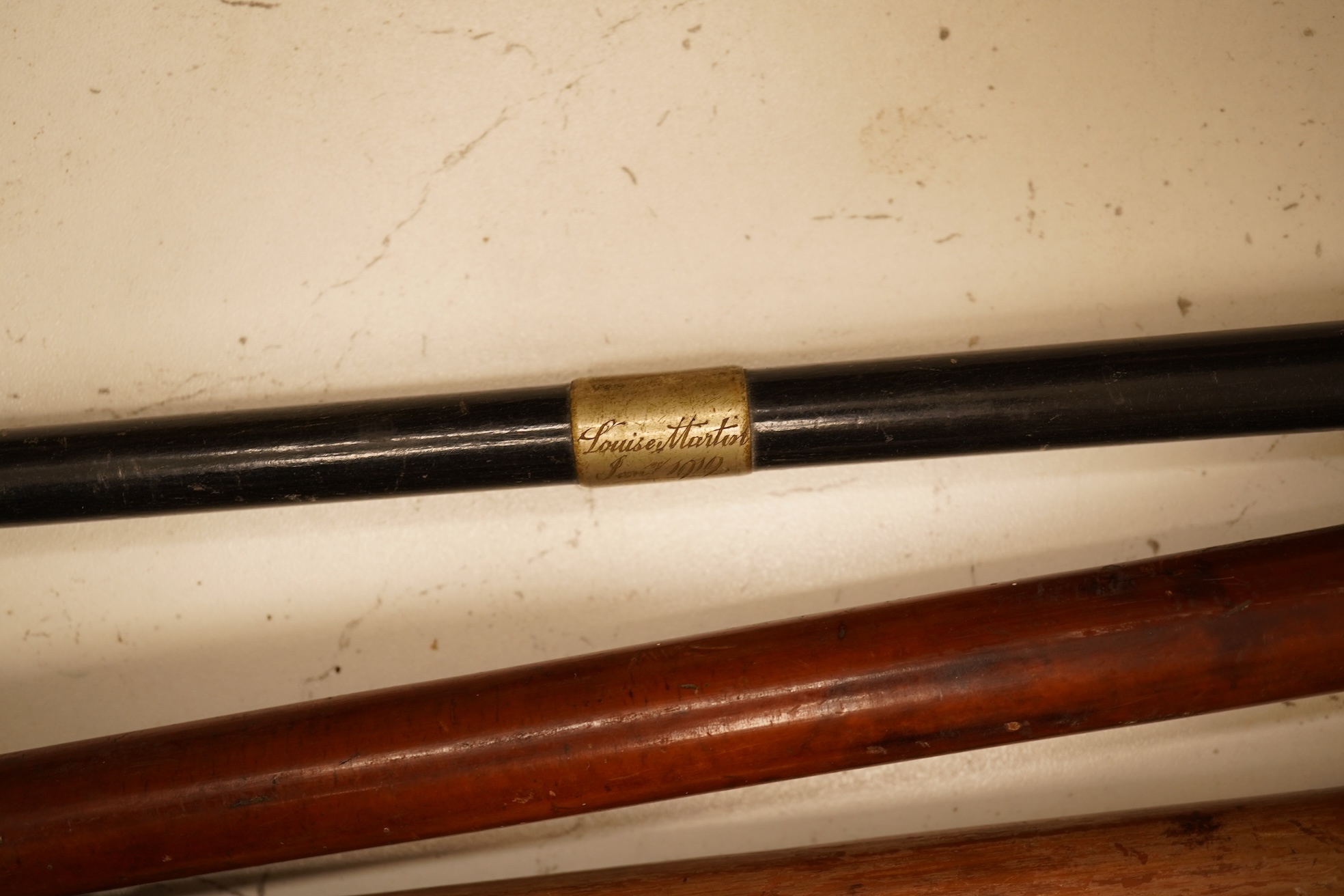 Three early 20th century antler handles riding crops with silver mounts and a swagger stick engraved Louise Martin, 1919